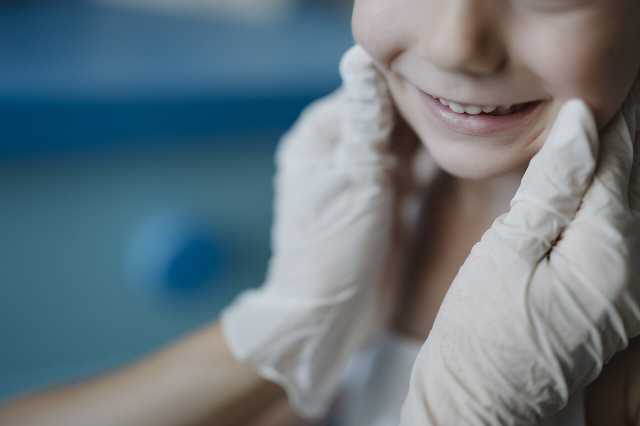Criança sorrindo durante atendimento odontopediátrico